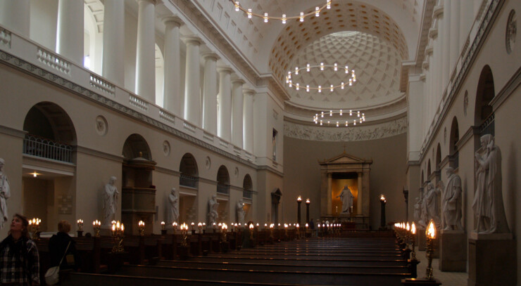 Københavns Domkirke indvendigt med lys ved bænkene under kirkens hvide hvælving