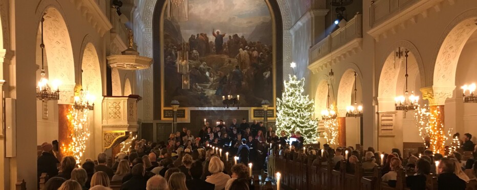 a lit christmas tree in a church full of happy people