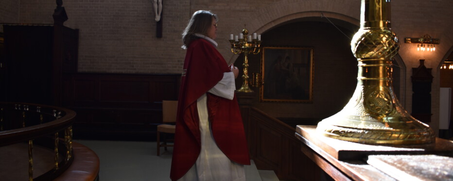 Pastor Maria Fihl stands in front of the altar in her special pentecostal pastoral gown