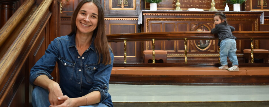 olga sits in front of the altar in the eliaskirke in copenhagen