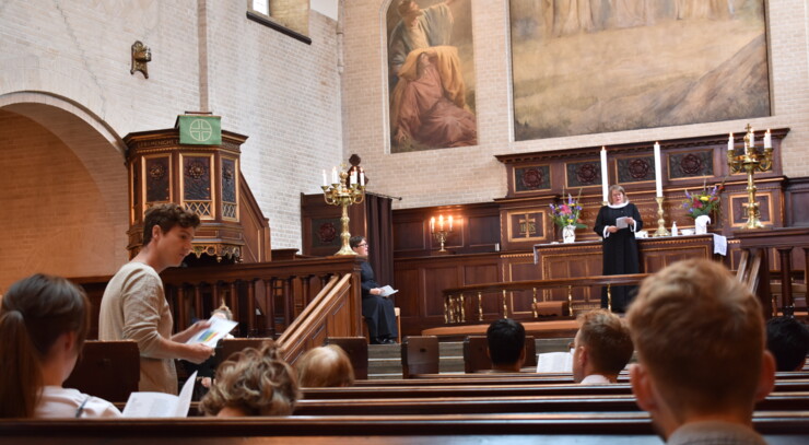 A photo taken from the pews of the Elias Church during a Sunday Jazz Service. In front of the altar stands Pastor Maria Fihl