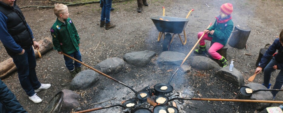 KFUM-Spejdere omkring et lejrbål med bålpander